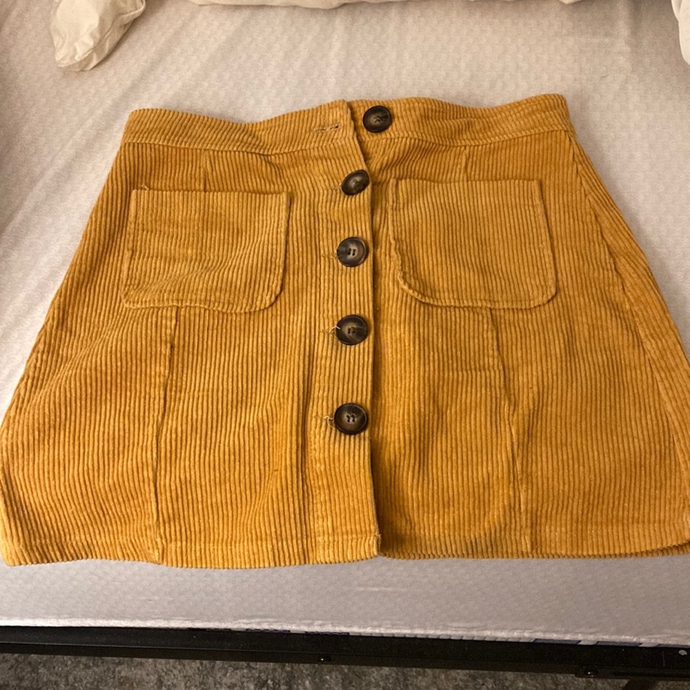 Mustard colored small corduroy skirt with button up detail by Francesca’s.